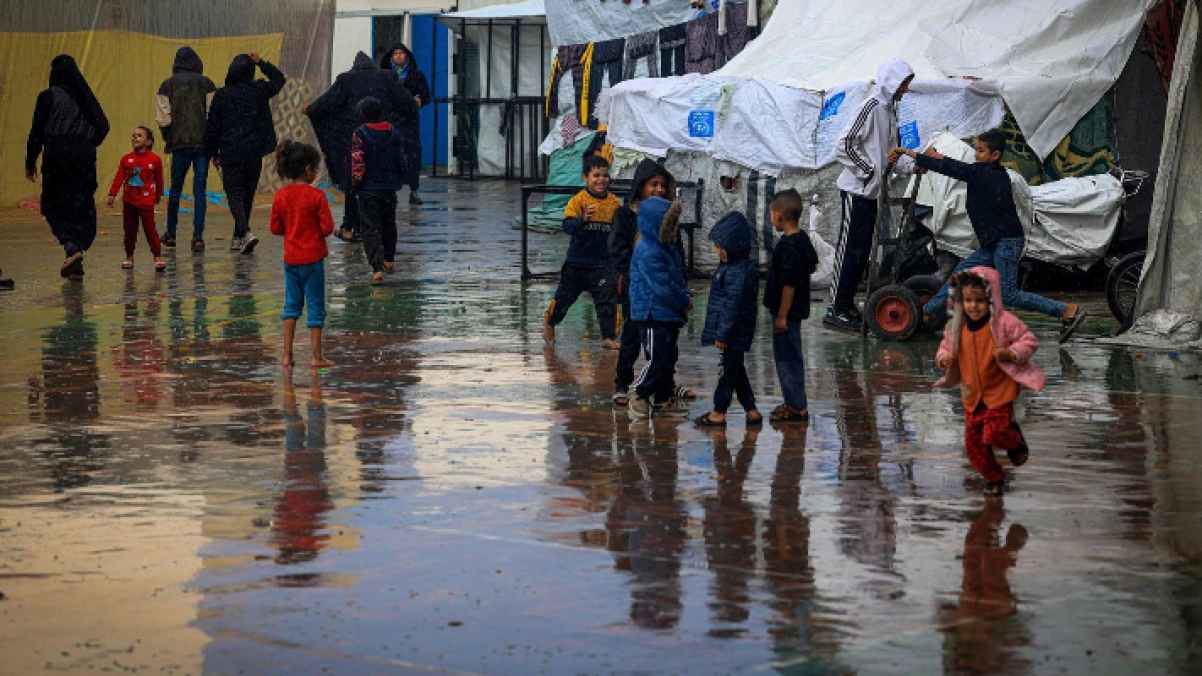 مشهد يفطر القلب.. فلسطيني يحمل صغيرة مكفنة وسط هطول الأمطار الغزيرة - فيديو