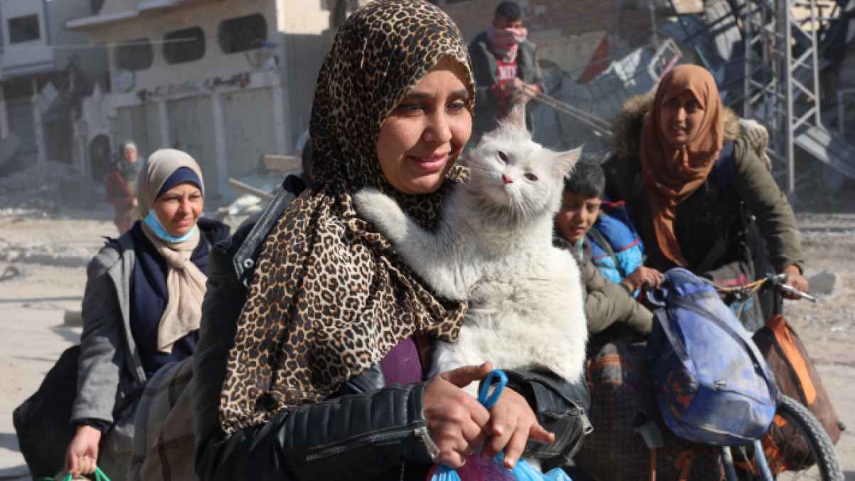 ما أجمل إنسانيتها!.. حملت قطتها رغم انعدام الحياة في القطاع