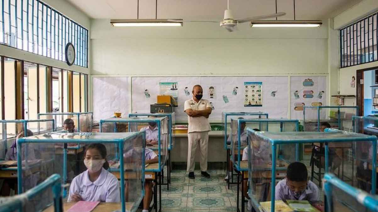 إجراءات الوقاية من فيروس كورونا فى مدارس تايلاند.. صناديق بلاستيك وكمامات.. صور