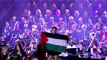 متضامنون يرفعون العلم الفلسطيني خلال حفلا في ملبورن الإسبانية