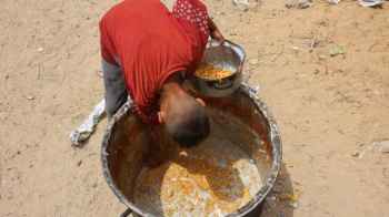 A heartbreaking image… he collects leftover food after a long wait.